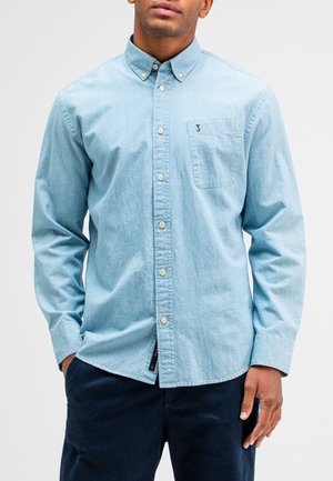 Light blue, button-up shirt made of denim with a chest pocket and a small logo. Features a collar and adjustable cuffs. Soft texture.