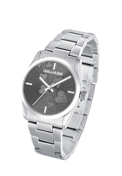 Hopeakylkinen rannekello, jossa on harmaa näyttö ja kimaltelevia sydänkuvioita sekä valkoiset tuntimerkit. Kellon alueella on brändinimi Zadig & Voltaire.