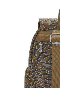 Brun tygryggsäck med ett vågigt mönster i blått och vitt. Har en silverdragkedja och ett texturerat bälte. Sidoficka synlig.