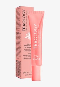 Gloss Tealogy Tea dans un tube pressable rose, avec une finition brillante. Accompagné d'une boîte assortie affichant les informations sur le produit et les ingrédients.
