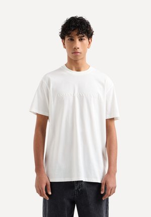 Biała bawełniana koszulka z krótkim rękawem, z wytłoczonym logo "ARMANI EXCHANGE" na piersi oraz luźnym krojem.