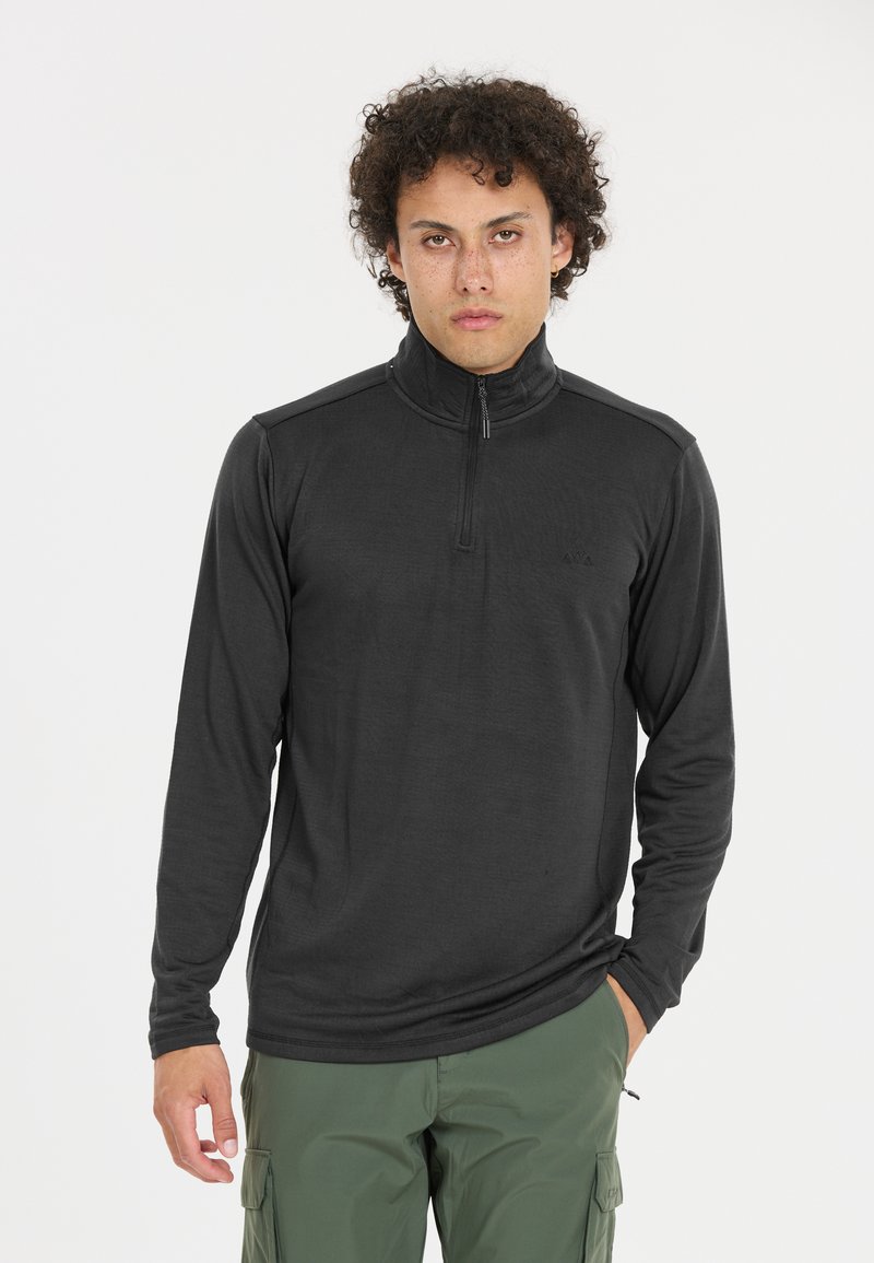 Schwarzer Langarm-Zip-Up-Pullover mit hohem Kragen, leichtem Stoff und subtilen Texturdetails. Kombiniert mit grünen Cargo-Hosen.