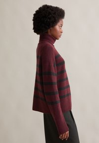 Burgunder- und schwarze gestreifte Rollkragensweater, aus weichem Material gefertigt, mit entspanntem Schnitt und gerippten Details an den Bündchen.