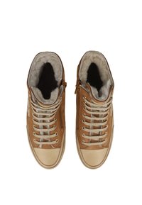 Hnědé vysoké tenisky s měkkým šedým kožešinovým podšíváním, bílými tkaničkami, zlatými očky a krémovou špičkou; mají boční zip pro snadné obouvání.