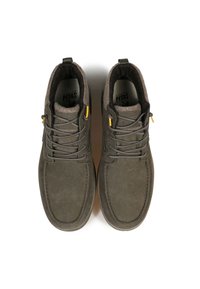 Zapatos de ante verde oliva con un suave forro interior, herrajes amarillos en contraste y un diseño de cordones tradicional. Punta redondeada y acentos texturizados.