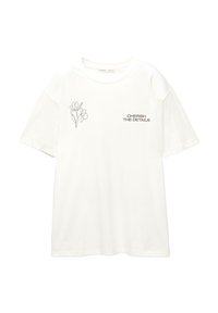 Hvid T-shirt med kort ærme, der har en lille blomsterlinjetegning på venstre bryst og teksten "VÆRDSÆT DETALJERNE" på højre bryst.