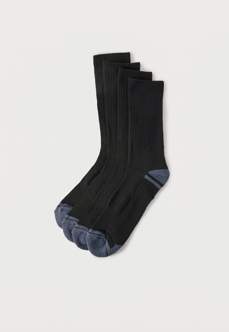 Quatre chaussettes de sport noires à texture côtelée, chacune avec des orteils et des talons gris foncé, soigneusement empilées sur un fond blanc uni.