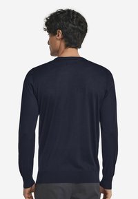 Marinblå tröja i mjukt tyg, med långa ärmar, rundhals och ribbad mudd och nederkant för en figursydd look.