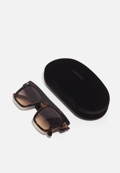 Ochelari de soare cu un design pătrat din fâșii de broască țestoasă și lentile gradient, însoțiți de un toc din catifea neagră, etichetat "TOM FORD."