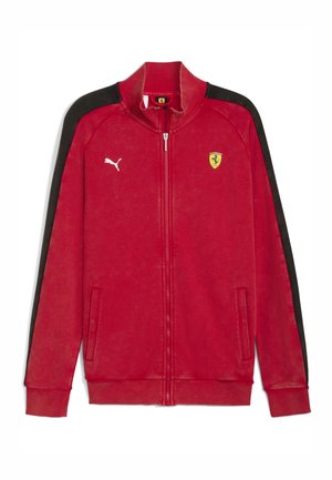 Chaqueta roja con cremallera hecha de un tejido suave, con rayas laterales negras, un logo de Puma en el pecho y un emblema de Ferrari en el lado izquierdo.
