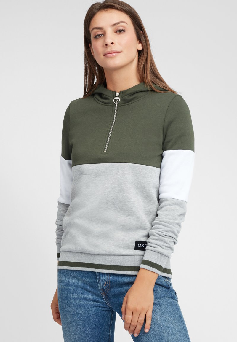Sweat-shirt à capuche présentant une partie supérieure vert olive, une section inférieure grise et des manches blanches. Comprend un col zippé et des poignets côtelés.