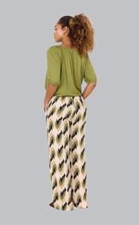 Olive green blouse with gathered neckline, paired with loose-fitting, patterned cream trousers featuring green and black wave prints.