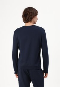 Marineblauwe sweatshirt met een ronde hals, lange mouwen, ribgebreide manchetten en zoom. Gemaakt van zachte stof, met een minimalistisch ontwerp.