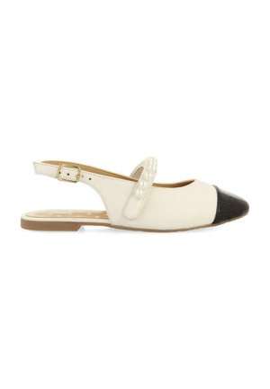 Zapato plano tipo slingback que presenta un cuerpo blanco, puntera negra, cuentas decorativas blancas en la correa y una suela marrón clara.