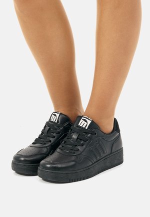 Zapatillas deportivas negras con parte superior de cuero texturizado, puntera redonda y suela de goma gruesa. Presenta cordones negros y un logo en la lengüeta.