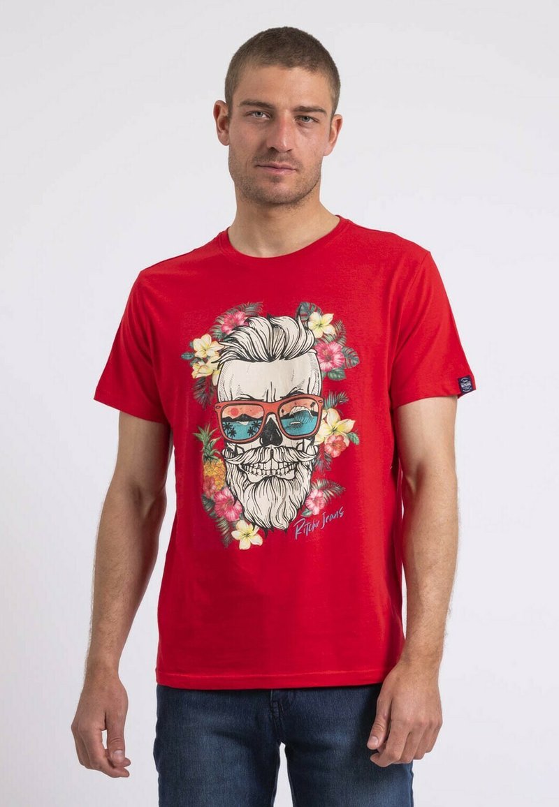 T-shirt en coton rouge avec un motif affichant un homme barbu portant des lunettes de soleil, entouré de motifs floraux et tropicaux. Coupe standard.