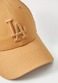 Hnedá baseballová čiapka s vyšívaným logom "LA", so štruktúrovanou korunou a zaobleným okrajom. Vyrobená z hladkej tkaniny s viditeľnými detailmi šitia.