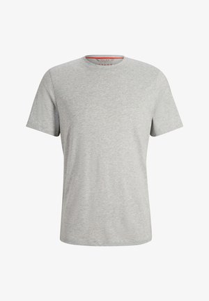 Szary t-shirt z okrągłym dekoltem i krótkimi rękawami, połączony z granatowymi spodniami typu slim fit i białymi butami sportowymi, na modelu męskim.