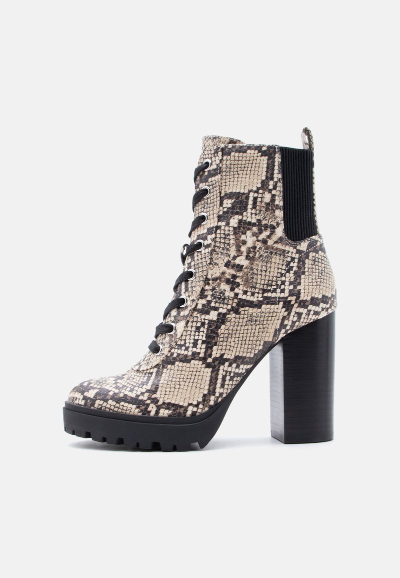 Bottine à talons hauts à lacets avec motif serpent beige et noir, panneau latéral élastique noir, semelle et talon épais noirs.