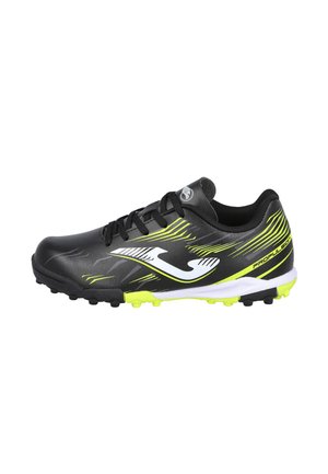 Botas deportivas negras con detalles en amarillo neón, logo blanco, cordones y tacos para césped artificial, diseñadas para uso deportivo al aire libre.