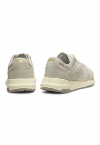 Paire de baskets beige en suède et mesh vue de dos, montrant des semelles intermédiaires texturées et le logo doré "MW" sur les languettes de talon.