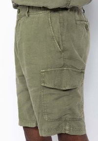 Olivengroene cargo shorts gemaakt van lichtgewicht stof met een elastische tailleband, zijzakken en een grote opgestikte zak op het linkerbeen.