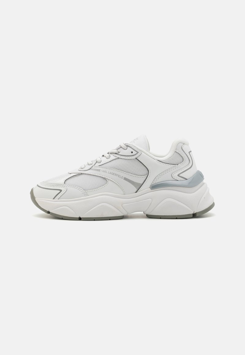 Baskets de sport blanches avec des détails en mesh et en synthétique, dotées d'une semelle épaisse, d'accents gris subtils et d'un design à lacets.