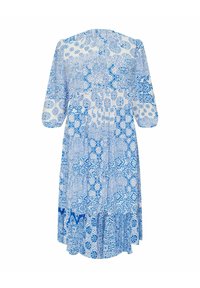 Modra in bela obleka s potiskom, ki ima okroglo neckline, rokave do komolcev in večplastni naborki na robu. Narejena je iz lahkotnega materiala.