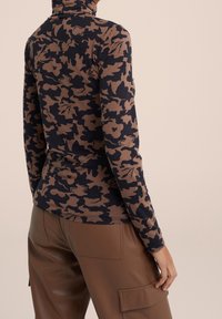 Dlouhý rukáv rolák vyrobený z měkké tkaniny, s hnědým a námořnickým maskáčovým vzorem. Přiléhavý design s zaobleným lemem.