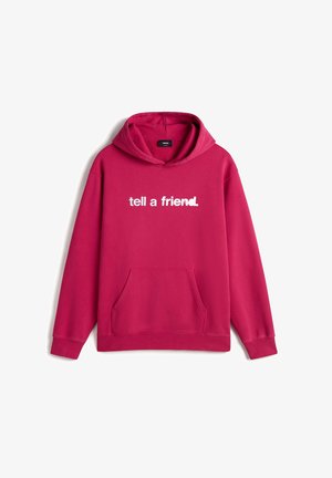 Lyserød hættetrøje med forlommer og hvid tekst "tell a friend" centralt på brystet.
