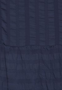 Námořnická tkanina s horizontálními pruhy a texturovaným zvrásněným vzorem. Měkký, lehký materiál s mírně zřaseným spodním okrajem.