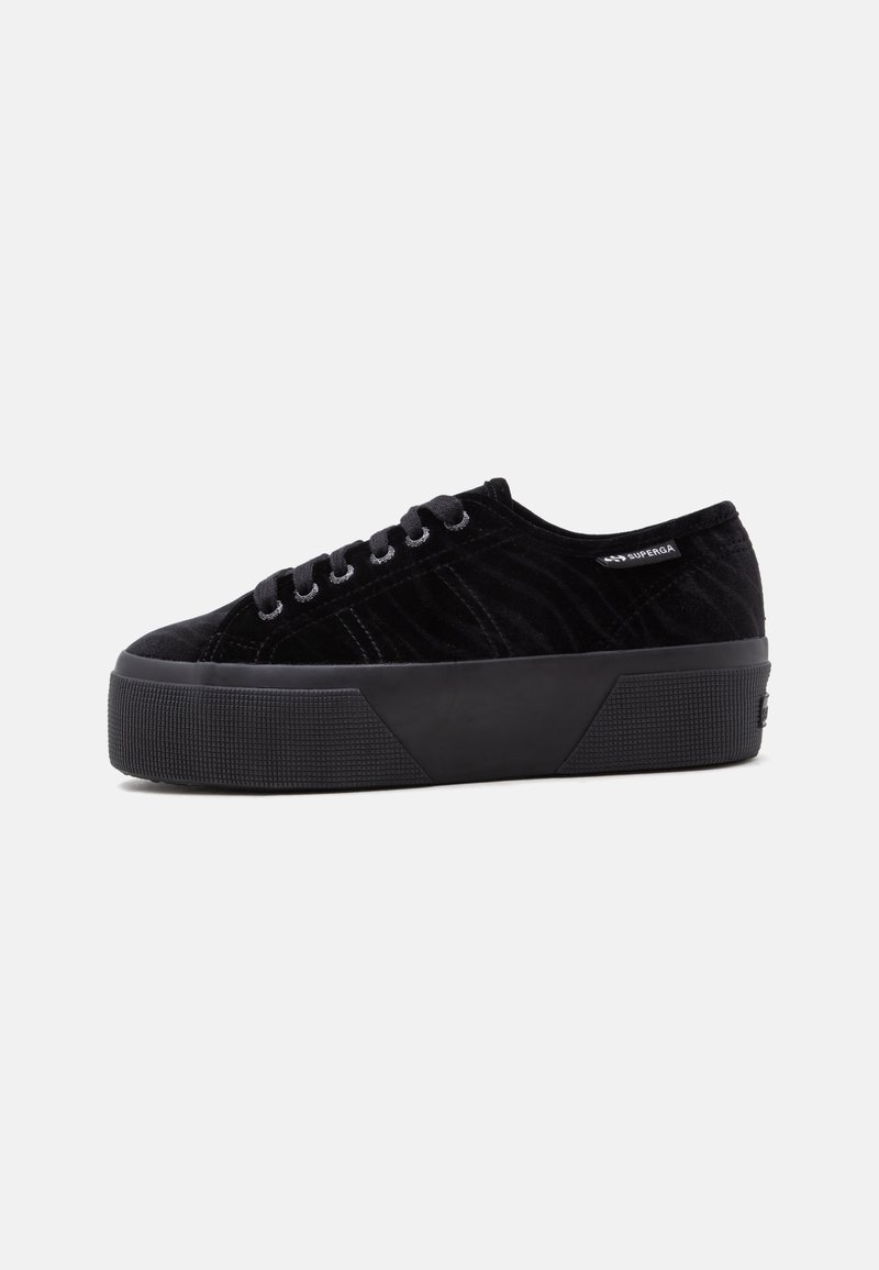 Μαύρο πλατφόρμα sneaker με υφή βελούδου, κορδόνια μπροστά και επώνυμη ετικέτα στο πλάι, εμφανίζεται από την εξωτερική πλευρά σε απλό φόντο.