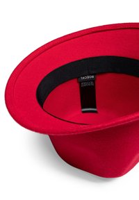 Red felt hat featuring a wide brim and a black inner band. Smooth texture with a clean, minimalist design. Label visible inside.