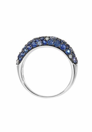 Silver ring featuring a curved design, adorned with various shades of blue and clear gemstones, highlighting intricate detail and texture.