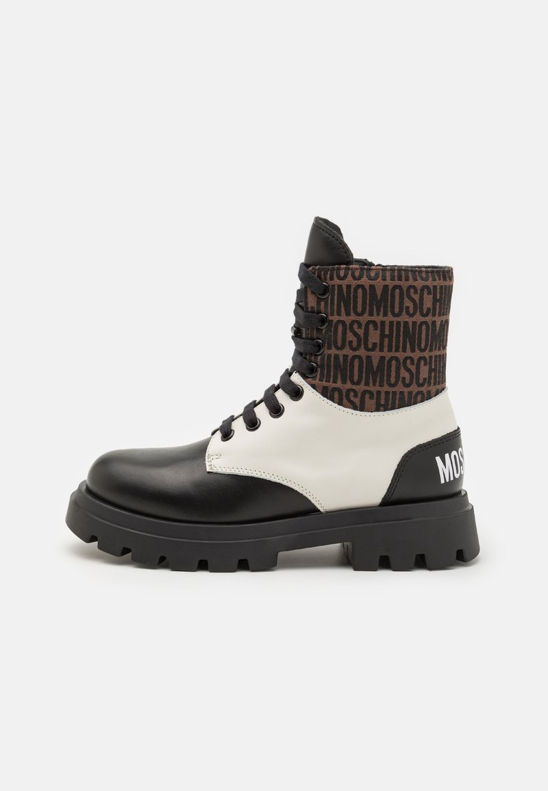 Bottine noire en cuir et synthétique avec un tige en tissu imprimé brun. Elle présente des lacets noirs et une semelle à crampons épaisse.