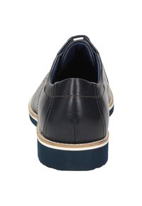 Scarpa in pelle navy con superficie testurizzata, cuciture marroni e suola in gomma bianca e blu. Presenta un tacco basso e un design con punta arrotondata.