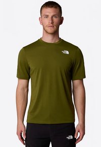 Oliivinvihreä, lyhythihainen T-paita pehmeästä kankaasta, pyöreällä pääntiellä ja pienellä valkoisella logolla vasemmassa rinnassa.