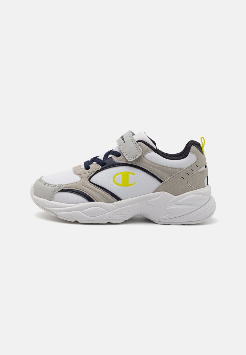 Weißer Sportschuh mit grauen und marineblauen Akzenten, ausgestattet mit einem Klettverschluss, strukturierten Paneelen und einem gelben Logo an der Seite. Chunky Sohlen-Design.