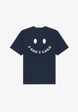 Navy blauwe katoenen t-shirt met korte mouwen, voorzien van een groot wit smiley gezicht ontwerp op de achterkant met de tekst "IK KAN ME NIETS AAN TREKKEN" eronder.