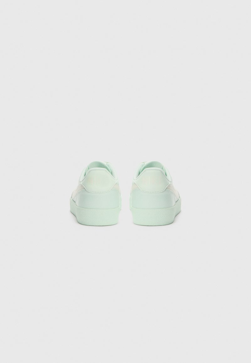 Minzgrüne Sneaker mit glattem Lederoberteil, gepolstertem Kragen, Gummisohle und minimalistischem Design. Rückansicht, die die Nähdetails zeigt.