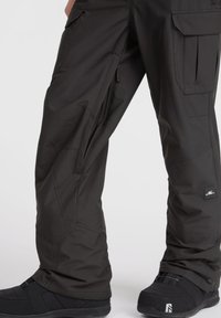 Sorte snowpants lavet af holdbart materiale. Har lynlåslukker til sideåbninger, cargo-lommer og en tætsiddende ankel-design.