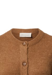 Brown wool cardigan featuring a round neckline, ribbed cuffs, and two brown buttons along the front. Label visible inside collar.