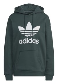 Mörkgrön hoodie med ficka framtill och vit Adidas-logotyp. Har en klassisk tre-stripes design på logotypen. Material av bomull.