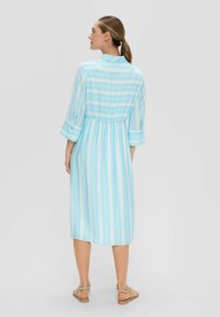 Hellblau gestreiftes Kleid mit drei Viertelärmeln, einem Kragen, geraffter Taille und knielangem Saum. Besticht durch einen weichen Stoff und einen dezenten Glanz.