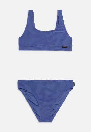 Conjunto de bikini azul texturizado de dos piezas con parte superior de escote redondo y braguitas de corte clásico sobre fondo blanco.