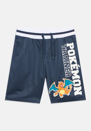 Tengerészkék sportnadrág fehér derékpánttal és zsinórral, jobbszáron "Pokémon Edző" felirattal és Charizard grafikával.