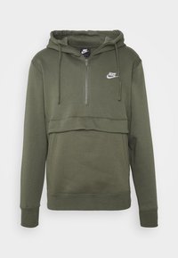 Mörkgrön Nike-hoodie med halvdragkedja, kenguruficka och snoddar. Har en vit logotyp på bröstet. Mjuk tygtextur.