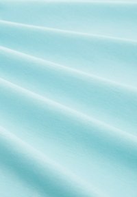 Svetle modrá látka s hladkým povrchem, s měkkými záhyby a jednotným vzhledem, ideální pro oblečení nebo domácí textil.