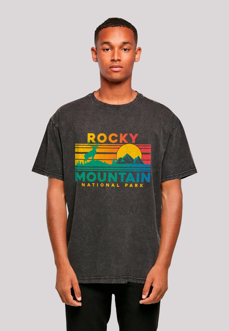 Black oversized t-shirt with a graphic of mountains and a sunset. Text reads "ROCKY MOUNTAIN NATIONAL PARK" in colorful letters.