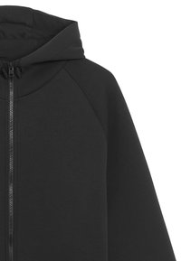 Svart zip-up hoodie med en slät textur, som har en dragsko i huvan och raglanärmar. Minimalistisk design utan mönster eller accenter.